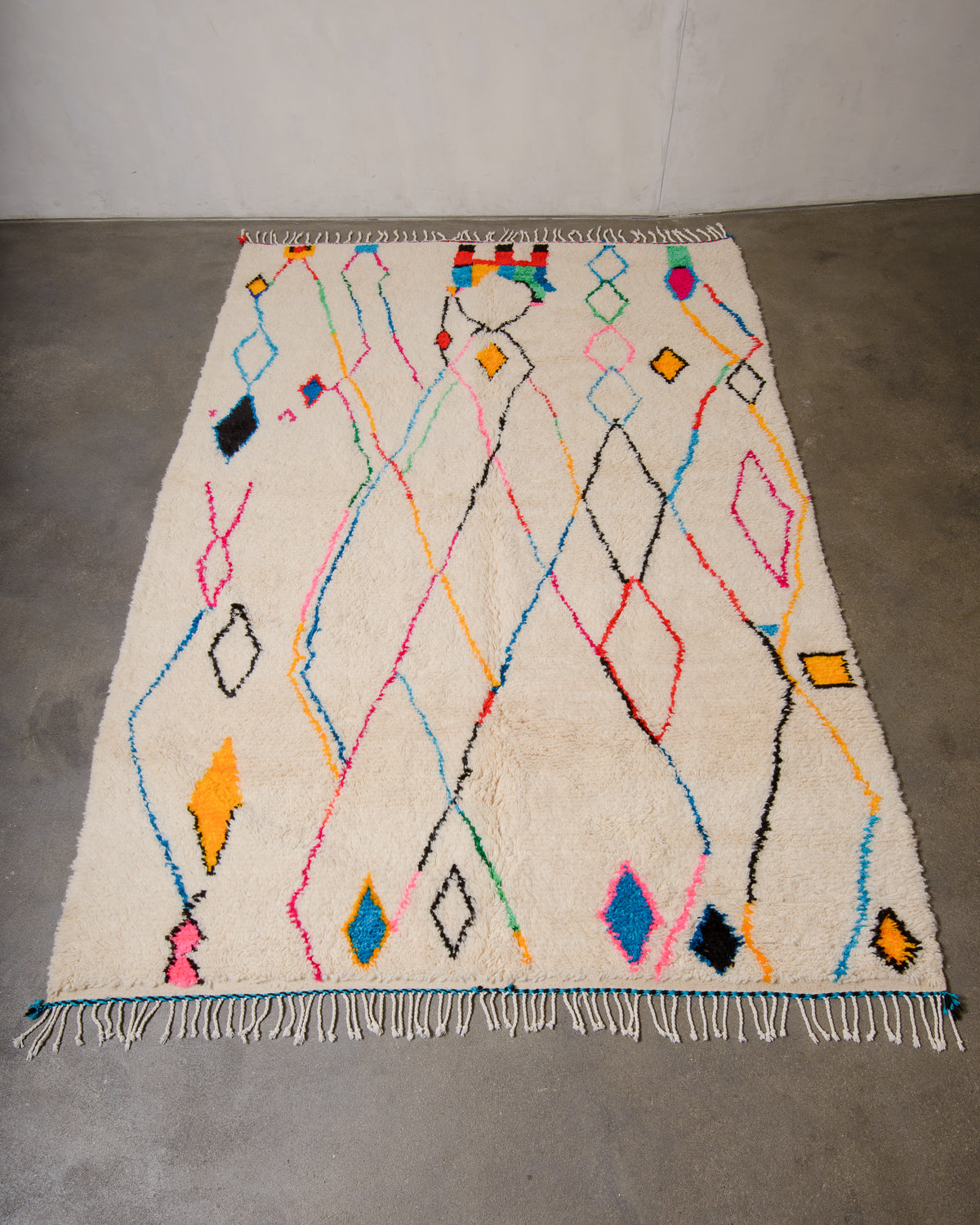 Berberlin Azilal rug made of fluffy wool and cotton, laying flat on a concrete floor.
